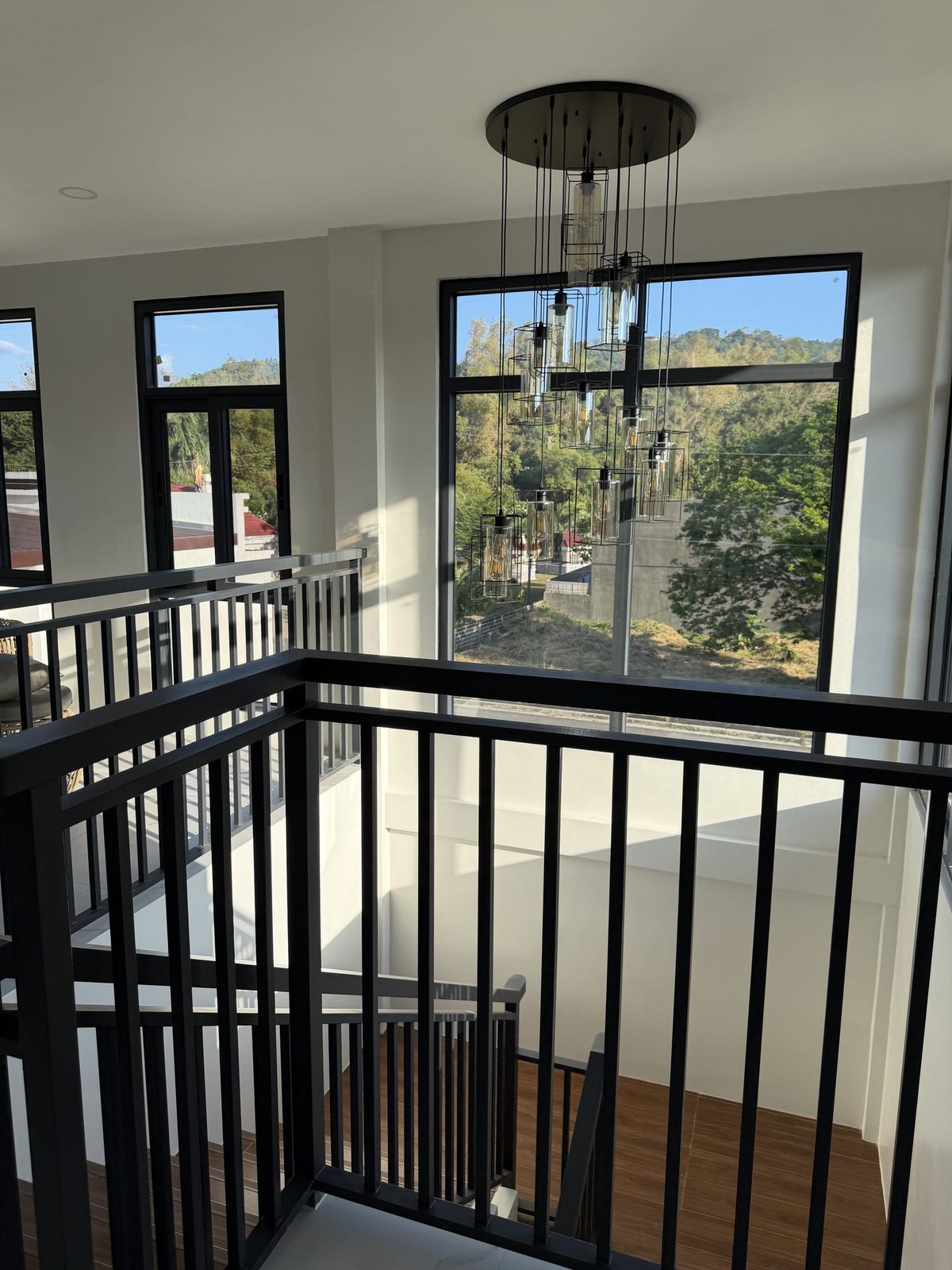 The mezzanine landing with tall windows looking out onto greenery